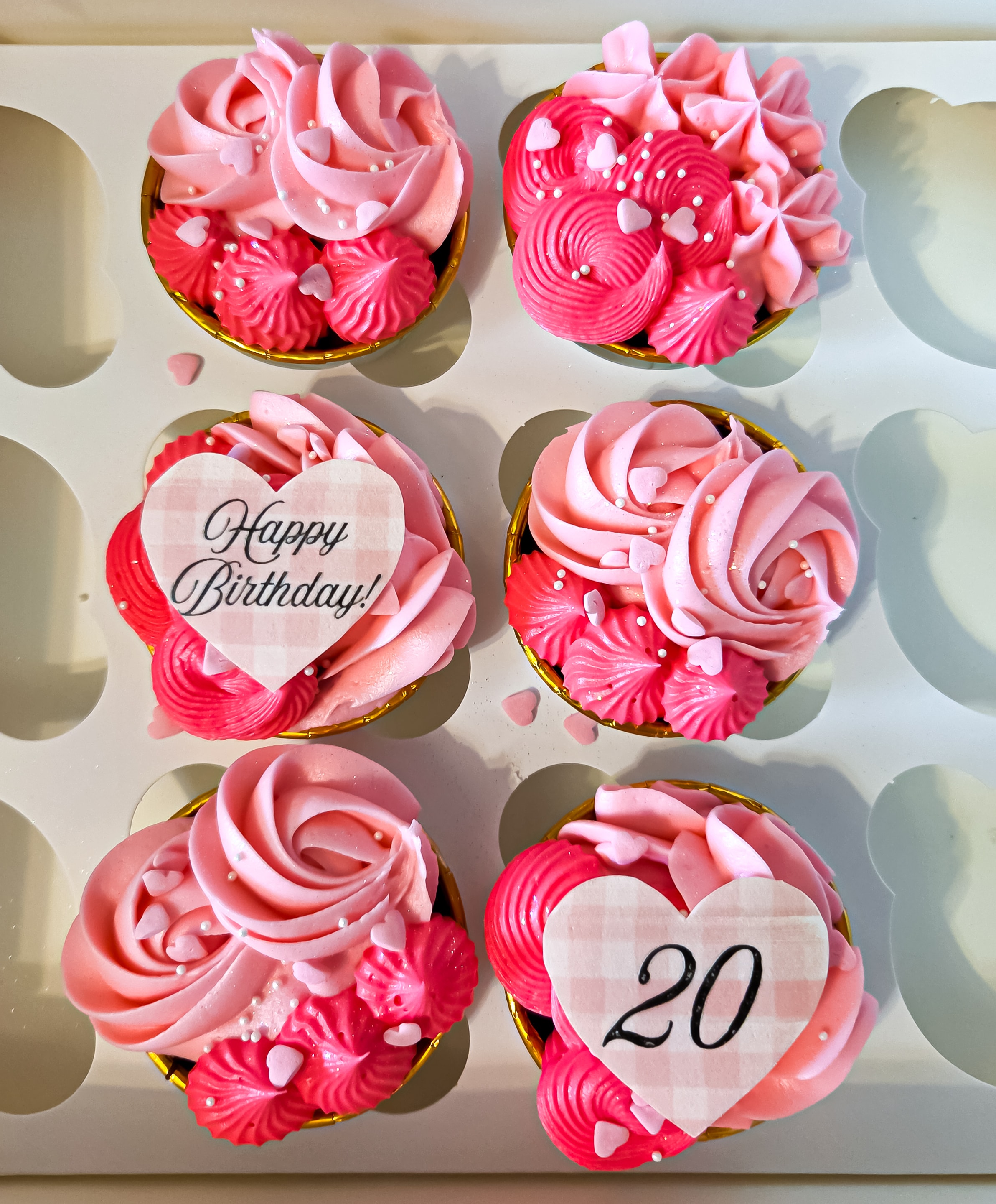 Pink and red birthday cupcakes with heart toppers