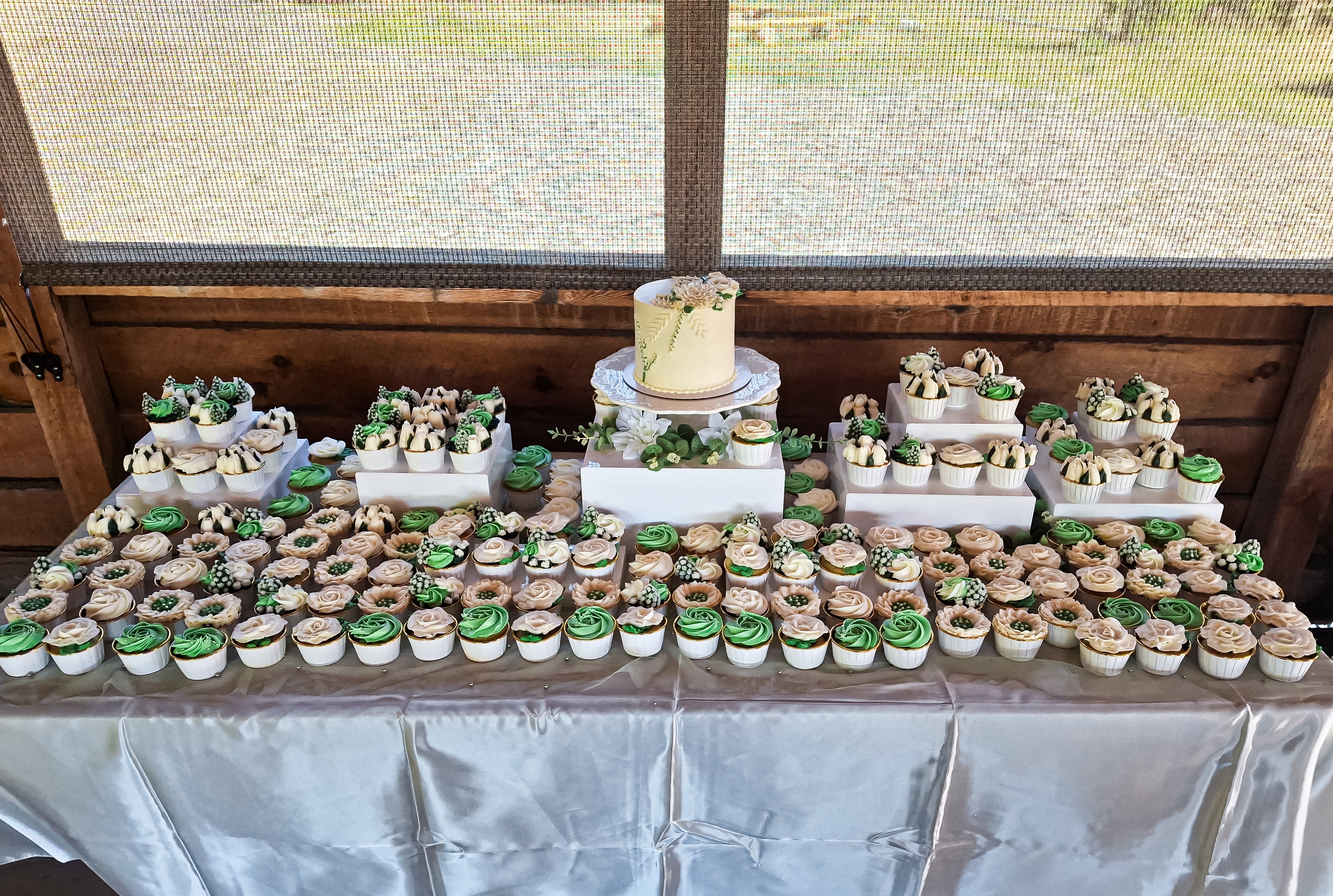 Beautifully arranged dessert table with tiered cake, cupcakes, and assorted mini treats