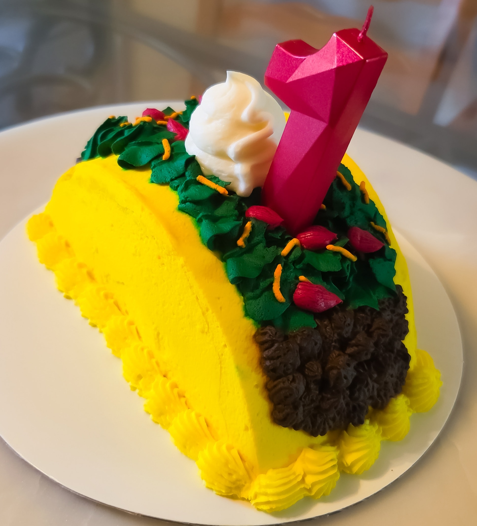 Colorful decorated cake with candle and flowers